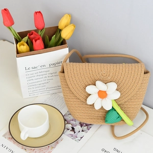 Close-up of handmade straw mini bag with large white daisy flower for summer beach look