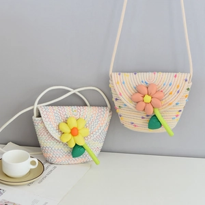Detail of hand-woven mini beach bags with floral accents and long shoulder straps