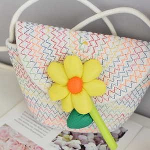 Detailed macro view of white woven mini beach bag with colorful waves and sunflower