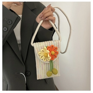 Detail of a handmade floral knit crossbody phone bag with vibrant wool flowers