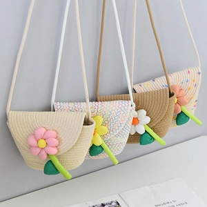 Detail view of woven straw bags in various patterns with decorative 3D fabric flowers
