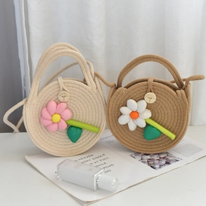 Détail de sacs tressés avec fleurs en relief et fermeture par bouton en bois naturel