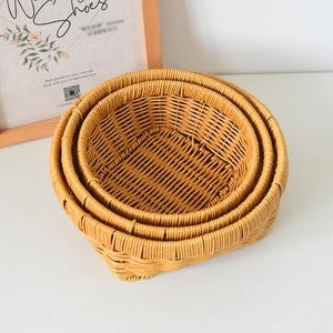 Close-up of three nested round woven storage baskets in warm brown rustic style