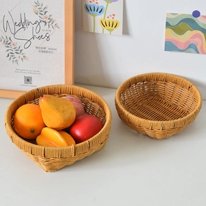 Detail of two-piece woven storage baskets filled with fresh fruits on a wooden table