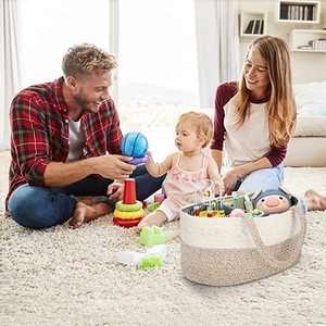 Detailed view of woven cotton rope diaper caddy holding various baby toys and essentials