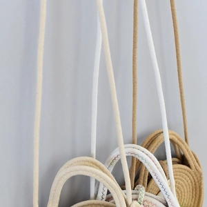 Détail de sacs en paille tressés avec coutures colorées en Z et bandoulières assorties