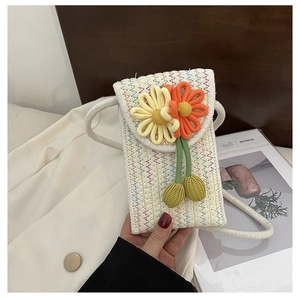 Detailed macro view of bohemian crochet phone bag with 3D woven flowers and vibrant zigzag stitching