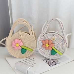 Détail de sacs ronds en paille tissée avec fleurs 3D et fermeture à bouton en bois