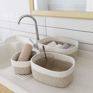 Detailed view of woven cotton rope storage baskets set on a modern bathroom vanity counter