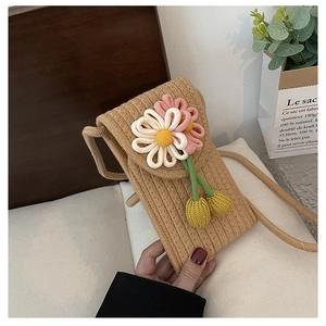 Detailed close-up of handmade woven phone bag featuring colorful 3D crochet flowers