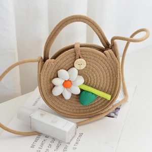 Détail du sac en paille tressée avec fleurs et fermoir en bois sur fond blanc pur