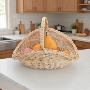 Detail view of a handcrafted wicker fruit basket with a curved handle on a kitchen counter