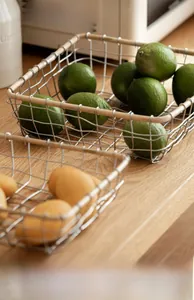 Detail of silver wire mesh fruit basket with wooden handle for kitchen storage