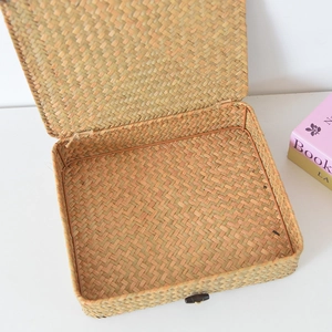 Macro detail of hand-woven seagrass storage box with natural texture and black button clasp