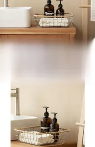 Close-up of wire storage basket with wooden rim holding towels and shampoo bottles