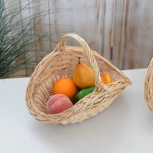 Detail view of a woven wicker picnic basket filled with fresh fruits and vegetables
