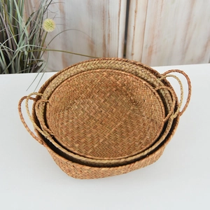 Nesting set of three hand-woven seagrass baskets with sturdy dual handles for home storage