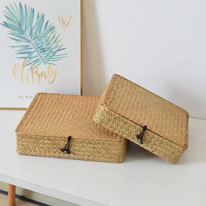 Detailed macro view of handmade straw storage box with wooden button and elastic closure