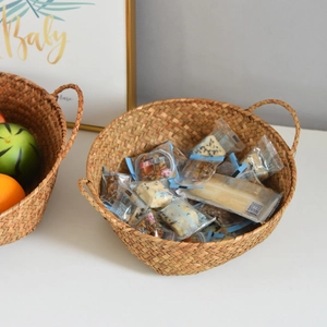 Detail of woven seagrass storage basket with handles for organizing snacks and fruits