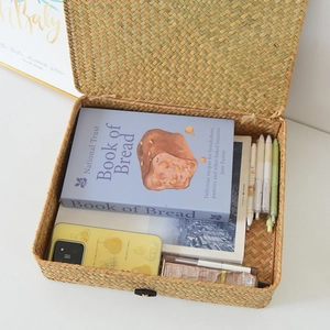 Top view of handmade woven storage box interior filled with books and stationery