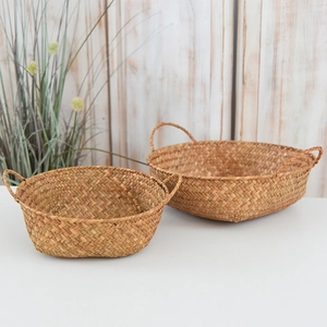 Detail of natural seagrass woven baskets with double handles in a two-piece storage set