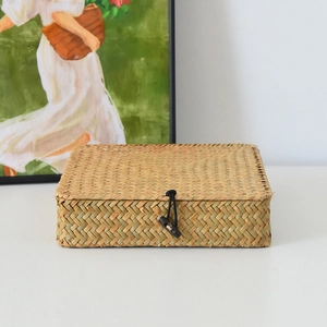 Detail der handgeflochtenen Seegras-Aufbewahrungsbox mit rustikalem Knopfverschluss