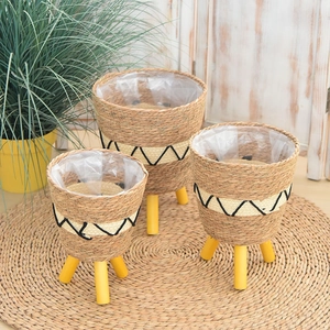 Detailed view of woven seagrass plant stands with waterproof lining and wooden legs