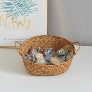 Close-up of hand-woven natural seagrass storage basket featuring sturdy double handles