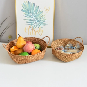 Detail of woven seagrass storage baskets with handles featuring fruit and snacks for home use