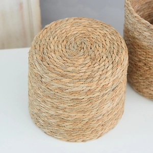 Detailed close-up showing the natural woven plant fiber texture of the round straw basket