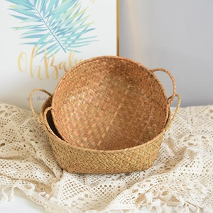 Detail of woven seagrass storage baskets set with double handles on lace cloth