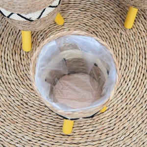 Top view of seagrass planter with black wave patterns and three yellow wooden legs