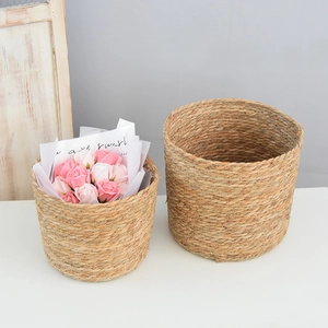 Detail of woven straw flower baskets featuring natural textures and decorative pink roses