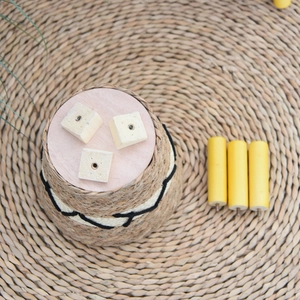 Detailed view of hand-woven rattan planter base with three solid wood legs in a Nordic style