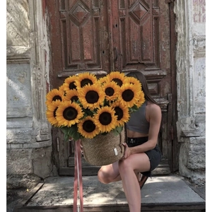 Rustic wicker basket with large sunflowers against a vintage brown wooden door background