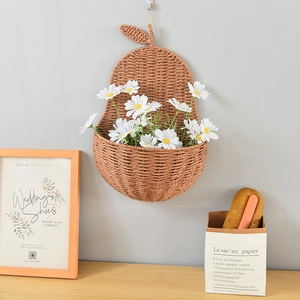 Detailed view of pear-shaped woven wall basket with white daisies for home decor