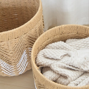 Detail of woven storage baskets with white geometric patterns and natural texture