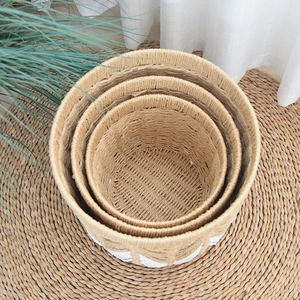 Detailed close-up of a three-piece nesting round woven basket set with white accents