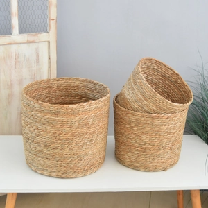 Three sizes of handcrafted woven seagrass storage baskets in natural cylinder shape