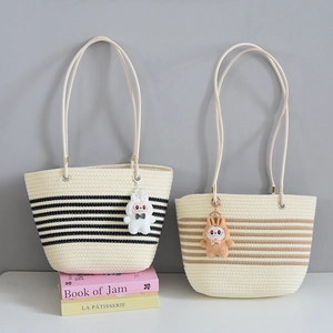 Close-up of woven tote bag texture with striped patterns and cute rabbit charm