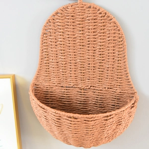 Detail showing the intricate hand-woven texture and coral pink finish of this wall basket