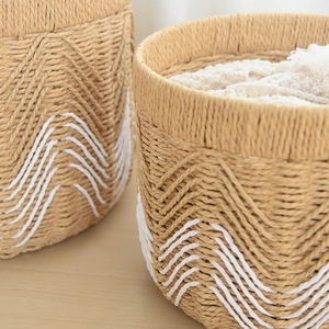 Close-up of hand-woven storage basket with white V-pattern and natural fiber texture