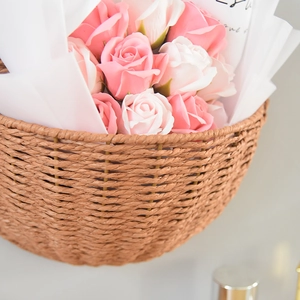 Close-up of hand-woven paper rope wall basket featuring pink and white silk roses