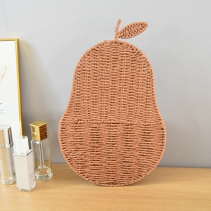 Detailed view of pear-shaped woven storage basket hanging in a warm home setting