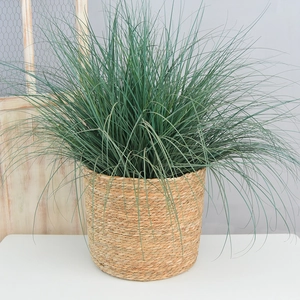 Detail of hand-woven straw basket with lush green decorative artificial plants inside