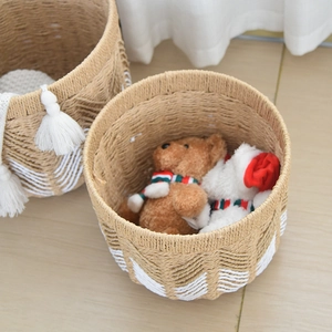 Detail of woven paper rope baskets with white wave patterns and decorative tassels