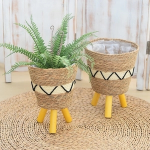 Close-up of woven straw plant baskets with solid wood legs and waterproof lining