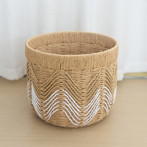 Detail of handwoven paper rope storage basket with decorative white mountain patterns
