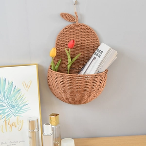 Pear-shaped dark brown woven wall basket used as a decorative floral hanging storage