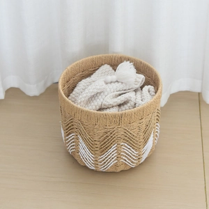 Detail of woven storage basket with white wave pattern and soft cotton blanket inside